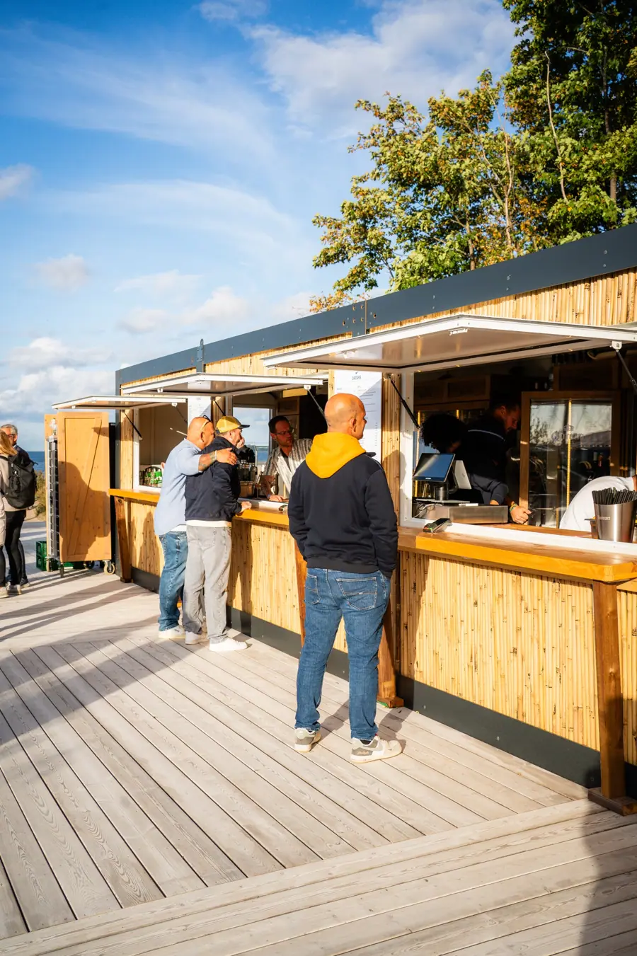 Gäste am Barcontainer auf dem Holzsteg