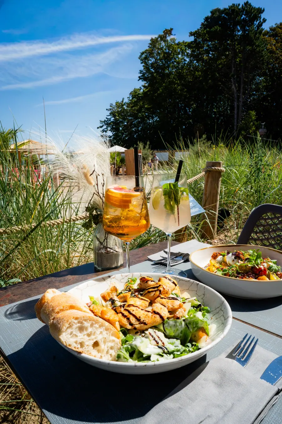 Caesar Salat und Spritz auf der Terrasse zwischen Strandgras